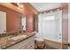 Bathroom featuring a tub with shower, granite countertop vanity, and well-lit mirror, offering a functional space at 1707 Cardinal Dr, Clearwater, FL 33759