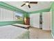 Green bedroom featuring carpet flooring, a ceiling fan, closet and natural light, creating a serene space at 1707 Cardinal Dr, Clearwater, FL 33759