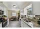 Spacious kitchen with white cabinets, granite countertops, and a view of the backyard at 1707 Cardinal Dr, Clearwater, FL 33759