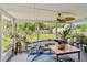 Bright sunroom featuring a ceiling fan, view of the backyard, and surfboard, perfect for relaxing and enjoying the outdoors at 1707 Cardinal Dr, Clearwater, FL 33759