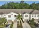Aerial view of a row of townhomes with manicured lawns, driveways, and mature trees at 17834 Althea Blue Pl, Lutz, FL 33558