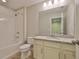 Well-lit bathroom featuring a shower, vanity with granite countertop, and modern fixtures at 17834 Althea Blue Pl, Lutz, FL 33558