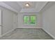 Bright bedroom features tray ceiling, neutral carpet, and abundant natural light from two windows at 17834 Althea Blue Pl, Lutz, FL 33558