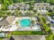 Aerial view of community pool featuring inviting lounge chairs, verdant landscaping, and pristine waters at 17834 Althea Blue Pl, Lutz, FL 33558