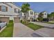 Inviting townhome featuring a lush lawn, mature tree, and private driveways and garages at 17834 Althea Blue Pl, Lutz, FL 33558