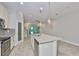 Bright kitchen with white cabinets, stainless appliances, and a large center island with a granite countertop at 17834 Althea Blue Pl, Lutz, FL 33558