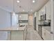 Modern kitchen featuring white cabinets, granite countertops, stainless steel appliances, and an island with pendant lighting at 17834 Althea Blue Pl, Lutz, FL 33558