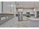 Bright kitchen features white cabinets, stainless steel appliances, granite countertops, and gray backsplash at 17834 Althea Blue Pl, Lutz, FL 33558