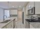 Beautiful kitchen boasting stainless steel appliances, granite countertops, gray backsplash, and an island with a sink at 17834 Althea Blue Pl, Lutz, FL 33558