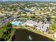 Extensive aerial view of a community, showcasing its pool, tennis courts, clubhouse, and surrounding residential area at 2032 Inverness Greens Dr # 76, Sun City Center, FL 33573