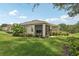 Beautiful backyard featuring a screened lanai, lush landscaping, and well-manicured lawn at 2032 Inverness Greens Dr # 76, Sun City Center, FL 33573