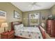 Cozy bedroom featuring neutral walls, a ceiling fan, and a bright window at 2032 Inverness Greens Dr # 76, Sun City Center, FL 33573