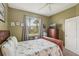 Cozy bedroom featuring neutral walls, a ceiling fan, and a bright window at 2032 Inverness Greens Dr # 76, Sun City Center, FL 33573