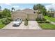 A well-maintained exterior of a beige residential building with a two-car garage, landscaping, and a driveway with car at 2032 Inverness Greens Dr # 76, Sun City Center, FL 33573