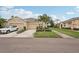 A well-maintained exterior of a beige residential building with a two-car garage, landscaping, and a driveway with car at 2032 Inverness Greens Dr # 76, Sun City Center, FL 33573