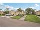 A well-maintained exterior of a beige residential building with a two-car garage, landscaping, and a driveway with car at 2032 Inverness Greens Dr # 76, Sun City Center, FL 33573