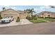 A well-maintained exterior of a beige residential building with a two-car garage, landscaping, and a driveway with car at 2032 Inverness Greens Dr # 76, Sun City Center, FL 33573