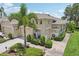 Well-maintained home with a lush garden, tropical plants, and a driveway leading to a garage at 2032 Inverness Greens Dr # 76, Sun City Center, FL 33573