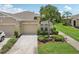 Charming home featuring a well-manicured lawn, beautiful landscaping, and an attached two-car garage at 2032 Inverness Greens Dr # 76, Sun City Center, FL 33573