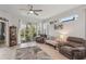 Bright and airy living room featuring a glass sliding door to outdoor space, comfortable furniture and a ceiling fan at 2032 Inverness Greens Dr # 76, Sun City Center, FL 33573