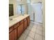 Bathroom featuring double sinks, wooden cabinets, and a glass-enclosed walk-in shower at 221 Fairmont Dr, Spring Hill, FL 34609