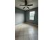 This bedroom features tile floors, a window with blinds, and a ceiling fan at 221 Fairmont Dr, Spring Hill, FL 34609