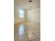 Open living room with tiled floors, chandelier lighting and a large window with natural light at 221 Fairmont Dr, Spring Hill, FL 34609