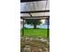 View of backyard from covered patio area with mature landscaping and lawn at 221 Fairmont Dr, Spring Hill, FL 34609