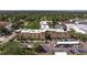 Aerial view of a condo complex featuring parking, manicured lawn, and lots of trees at 2525 W Bay Dr # B43, Belleair Bluffs, FL 33770