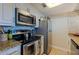 Well-equipped kitchen featuring stainless steel appliances, granite countertops, and mosaic tile backsplash at 2525 W Bay Dr # B43, Belleair Bluffs, FL 33770