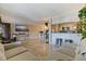 Open-concept living area with tile flooring, sofa, kitchen bar and appliances, and a television at 2525 W Bay Dr # B43, Belleair Bluffs, FL 33770