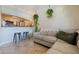 Bright living room featuring a sofa, bar stool seating at the kitchen counter, and hanging plants at 2525 W Bay Dr # B43, Belleair Bluffs, FL 33770