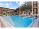 Swimming pool featuring several chair and table seating arrangements and condo building in the background at 2525 W Bay Dr # B43, Belleair Bluffs, FL 33770