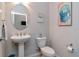 Charming powder room with pedestal sink, toilet, oval mirror, and grey paint at 26972 Evergreen Chase Dr, Wesley Chapel, FL 33544