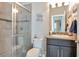 Bathroom featuring a glass shower door, black granite vanity, toilet, and decorative mirror at 26972 Evergreen Chase Dr, Wesley Chapel, FL 33544