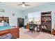 A light blue bedroom featuring a bed, desk, dresser, and bookshelf at 26972 Evergreen Chase Dr, Wesley Chapel, FL 33544
