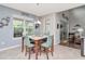 Bright dining room features modern chandelier, sliding glass doors, and large window overlooking the backyard at 26972 Evergreen Chase Dr, Wesley Chapel, FL 33544