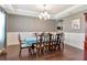 Traditional dining room with hardwood floors, wainscotting, a chandelier, and a large table at 26972 Evergreen Chase Dr, Wesley Chapel, FL 33544