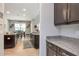 Spacious kitchen featuring granite countertops and dark wood cabinets with views into the dining room at 26972 Evergreen Chase Dr, Wesley Chapel, FL 33544