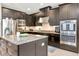 Close-up of a kitchen with dark cabinetry, stainless steel appliances, a center island, and granite countertops at 26972 Evergreen Chase Dr, Wesley Chapel, FL 33544