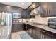 Kitchen area featuring stainless steel appliances, dark cabinets, granite countertops, and tile flooring at 26972 Evergreen Chase Dr, Wesley Chapel, FL 33544