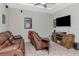 A cozy upstairs living area featuring a comfortable leather sofa and a large television at 26972 Evergreen Chase Dr, Wesley Chapel, FL 33544