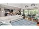 Open-concept living room with dark accents, a large white sofa, and a view of the pool at 26972 Evergreen Chase Dr, Wesley Chapel, FL 33544