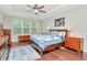 Spacious main bedroom featuring a ceiling fan, tray ceiling, wood floors, and natural light from the windows at 26972 Evergreen Chase Dr, Wesley Chapel, FL 33544