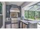 Outdoor kitchen with stainless steel appliances, bar seating, and stone accents at 26972 Evergreen Chase Dr, Wesley Chapel, FL 33544
