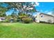 Large backyard featuring lush green grass, mature trees and landscaping offering privacy and space at 2806 Fairway View Dr, Valrico, FL 33596