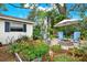 A beautiful backyard with many colorful plants, seating area, an umbrella, and a fire pit at 2806 Fairway View Dr, Valrico, FL 33596