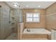 Bathroom featuring walk-in shower, soaking tub and travertine tile at 2806 Fairway View Dr, Valrico, FL 33596