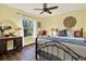 Cozy bedroom with wood floors, ceiling fan, a large window, and a dresser and mirror at 2806 Fairway View Dr, Valrico, FL 33596