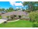 Inviting single-story home featuring a manicured lawn, mature landscaping, and a charming walkway to the entrance at 2806 Fairway View Dr, Valrico, FL 33596
